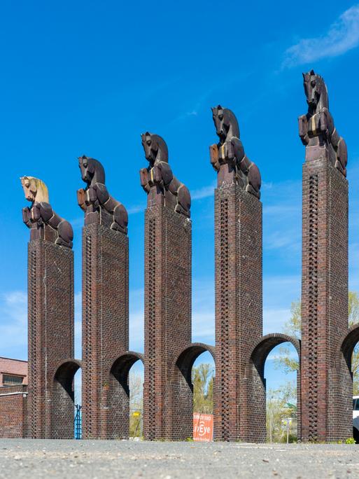 Das steinerne Pferdetor im Stadtpark von Magdeburg ragt in den wolkenlosen Himmel. Sechs Säulen mit den Tiernachbildungen bilden das 15 Meter hohe Pferdetor aus dem Jahr 1927. Das steinerne Pferdetor im Stadtpark von Magdeburg ragt in den wolkenlosen Himmel. Sechs Säulen mit den Tiernachbildungen bilden das 15 Meter hohe Pferdetor aus dem Jahr 1927.