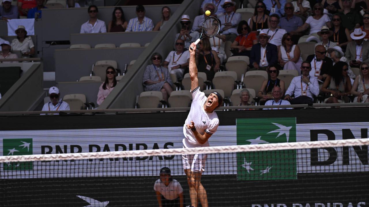 Alexander Zverev springt, um mit seinem Tennisschläger den Ball zu erreichen. Im Hintergrund sitzen mehrere Menschen auf der Besuchertribüne. 