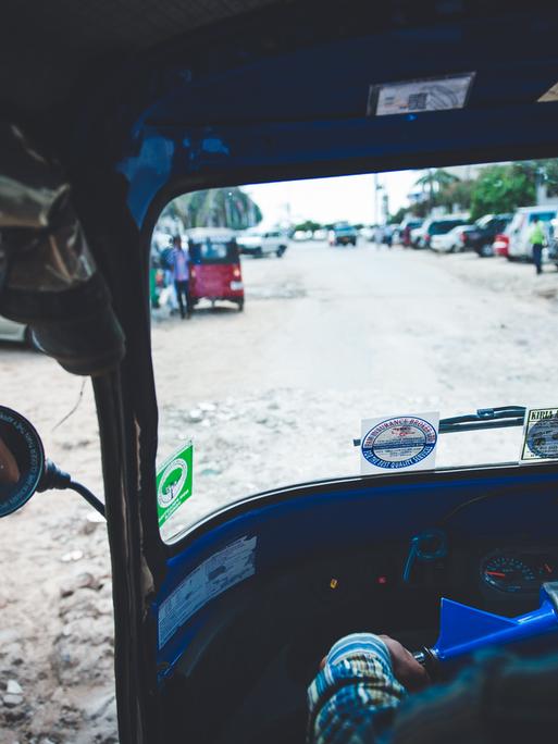 Blick aus einem Tuk-Tuk in Dar es Salaam auf eine Straße.