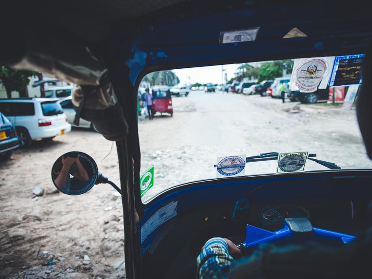 Blick aus einem Tuk-Tuk in Dar es Salaam auf eine Straße.