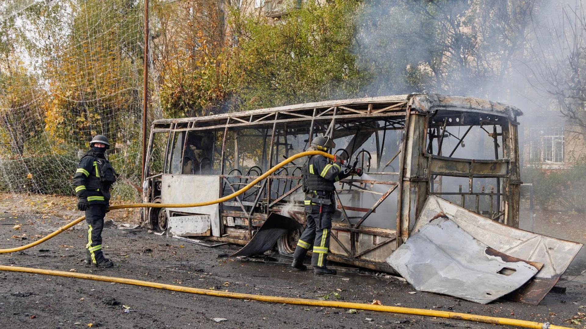 Feuerwehrleute löschen den Bus. Rauch steigt auf. Der Bus ist ganz ausgebrannt. Feuerwehrleute löschen den Bus. Rauch steigt auf. Der Bus ist ganz ausgebrannt.