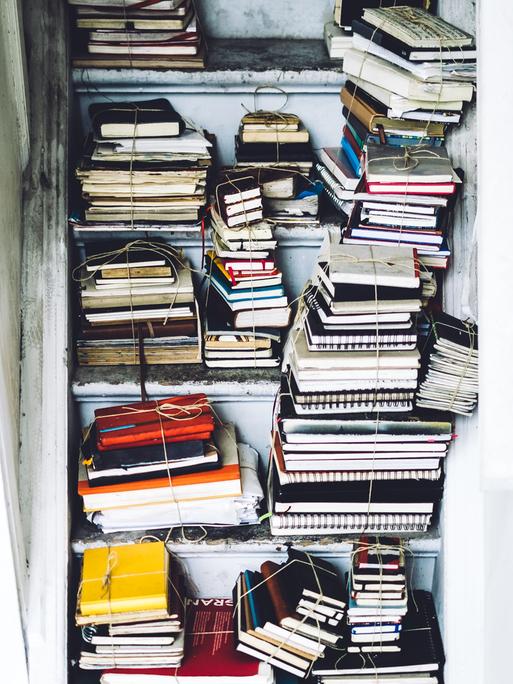Mehrere Stapel Notizbücher auf einer Treppe.