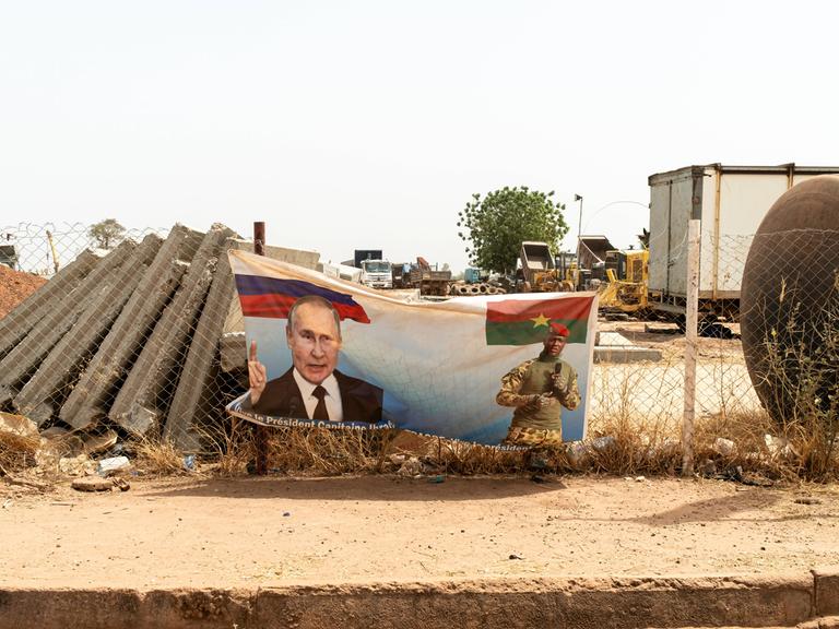 Ein Plakat an einer Straße am Rande von Ouagadougou in Burkina Faso. Darauf ist der russische Präsident Putin und der Übergangspräsident Ibrahim Traoré zu sehen.  