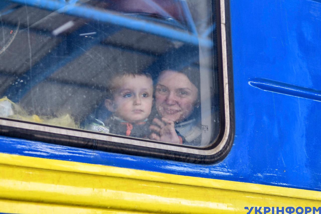 Eine Frau sitzt mit Kind in einem Evakuierungszug aus der Stadt Saporischschja.