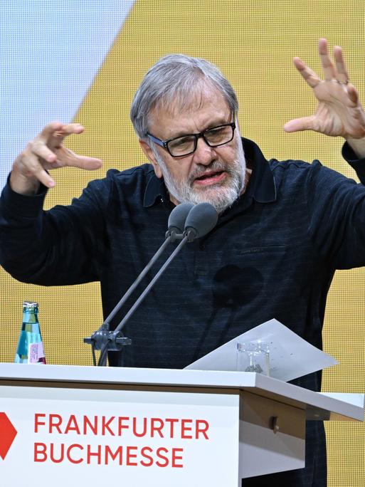 Der slowenische Philosoph Slavoj Zizek steht am Rednerpult und gestikuliert.