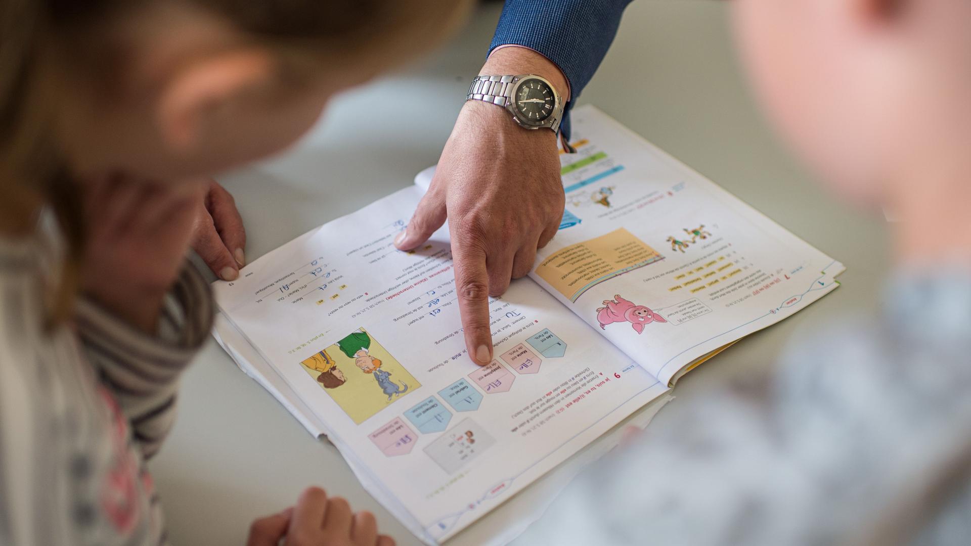 Gymnasium in Alsdorf (Nordrhein-Westfalen): Ein Lehrer zeigt während einer "Dalton Stunde" auf eine Lektion in einem Französisch-Lehrbuch. Gymnasium in Alsdorf (Nordrhein-Westfalen): Ein Lehrer zeigt während einer "Dalton Stunde" auf eine Lektion in einem Französisch-Lehrbuch.