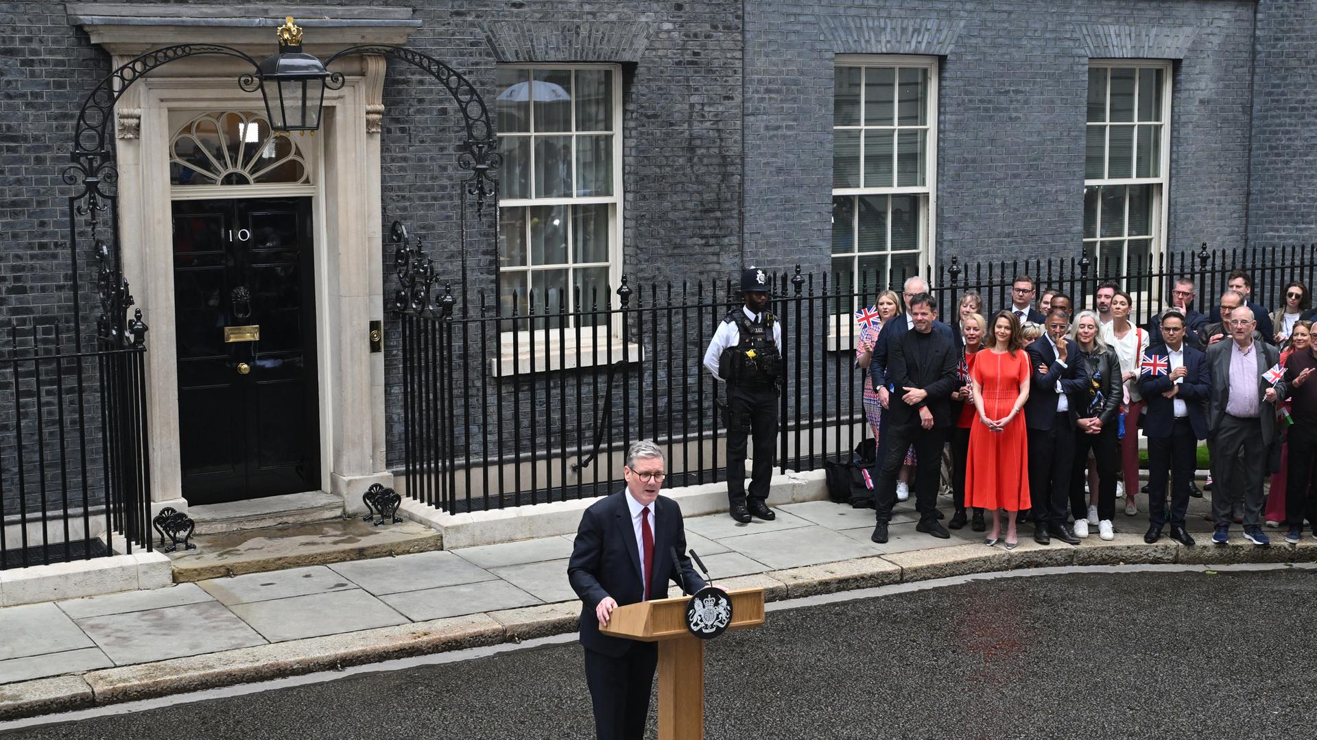 Keir Starmer steht vor seinem Amtssitz - 10 Downing Street - und hält eine Rede. Im Hintergrund stehen Teile seiner Anhängerschaft. Keir Starmer steht vor seinem Amtssitz - 10 Downing Street - und hält eine Rede. Im Hintergrund stehen Teile seiner Anhängerschaft.