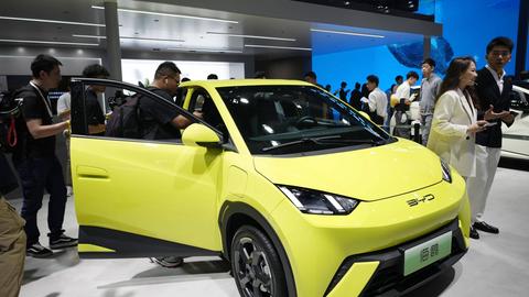 Auf der Motorshow im chinesischen Shanghai stellt die Firma BYD ihr E-Auto Seagull vor; es ist gelb. Besucher der Show sehen sich das Auto an (18.04.2023)