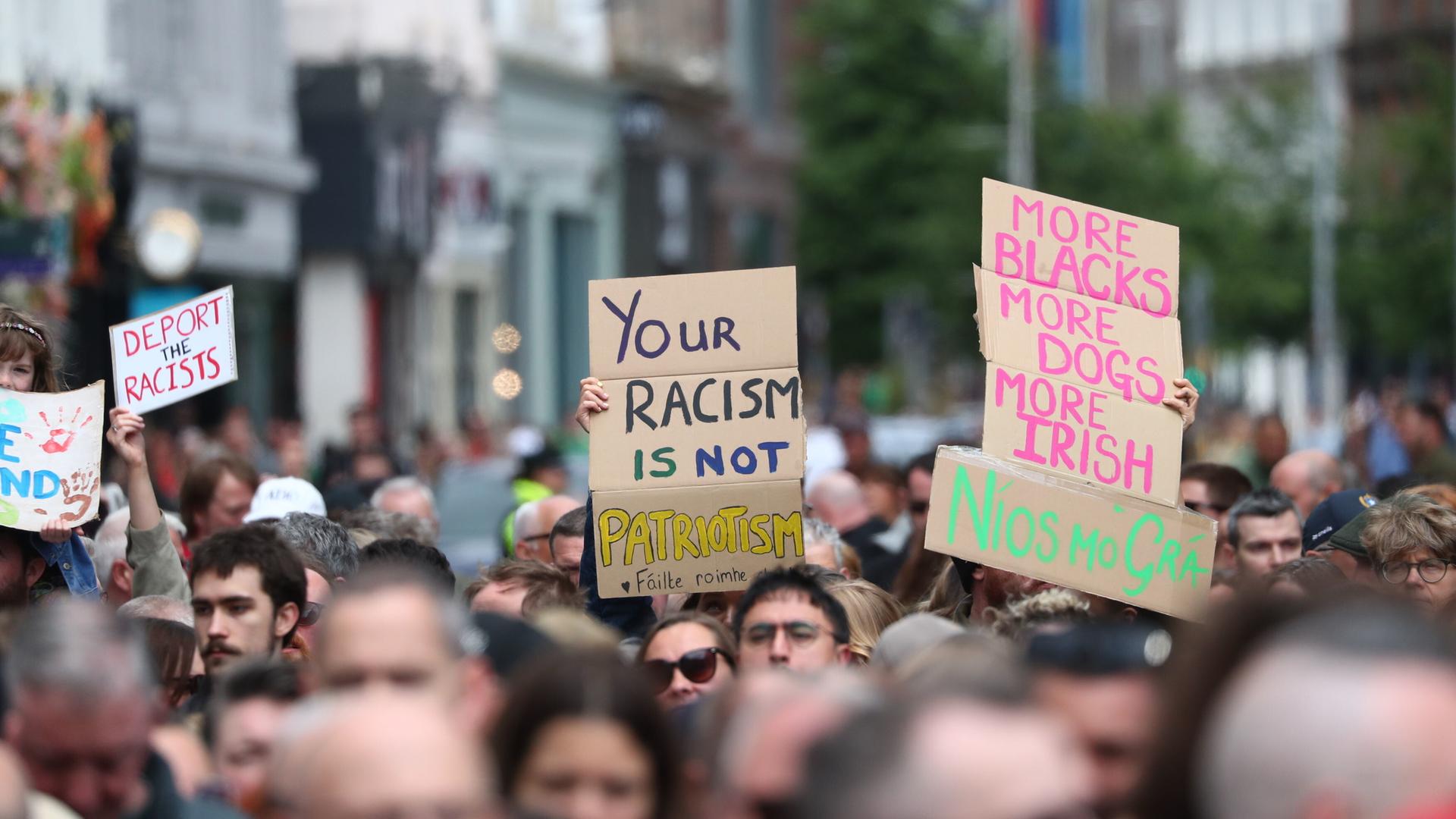Demonstranten halten Plakate mit Aufschriften wie "Euer Rassismus ist kein Patriotismus" in die Höhe Demonstranten halten Plakate mit Aufschriften wie "Euer Rassismus ist kein Patriotismus" in die Höhe