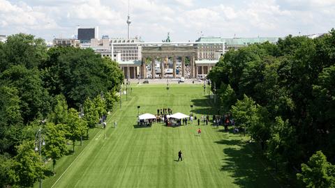 Zelte stehen während einer Pressekonferenz zu den Fanzonen bei der Fußball-Europameisterschaft 2024 rund um das Brandenburger Tor auf der mit Kunstrasen ausgelegten Fanmeile.