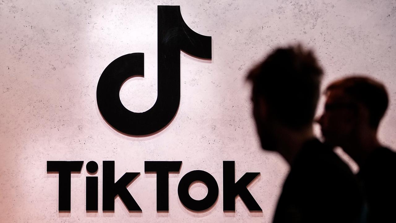 Das TikTok-Logo mit Schatten von Menschen