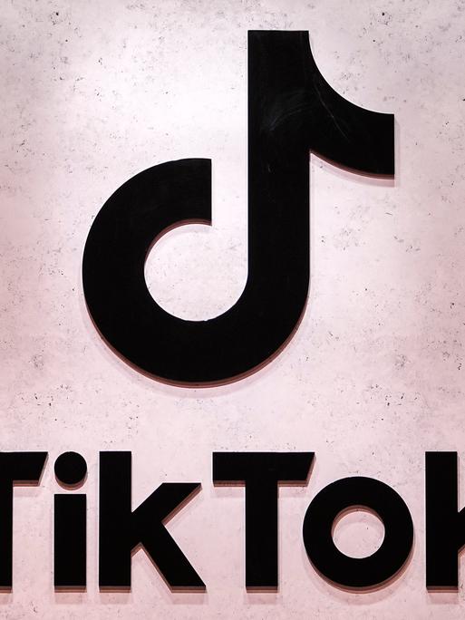 Das TikTok-Logo mit Schatten von Menschen