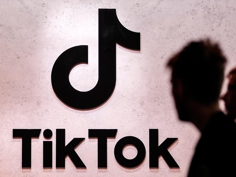 Das TikTok-Logo mit Schatten von Menschen