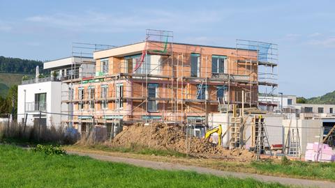 Ein eingerüsteter Neubau auf der grünen Wiese.