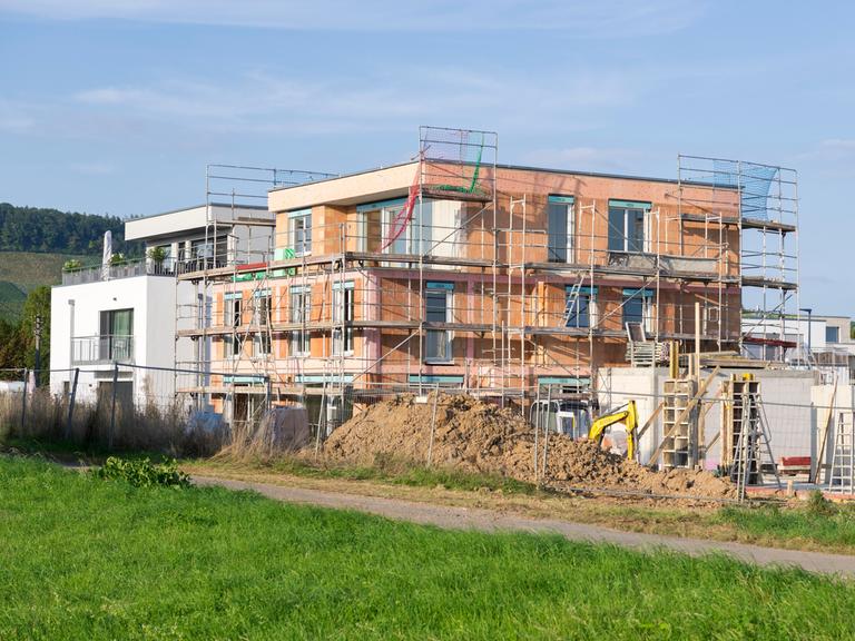 Ein eingerüsteter Neubau auf der grünen Wiese. 
