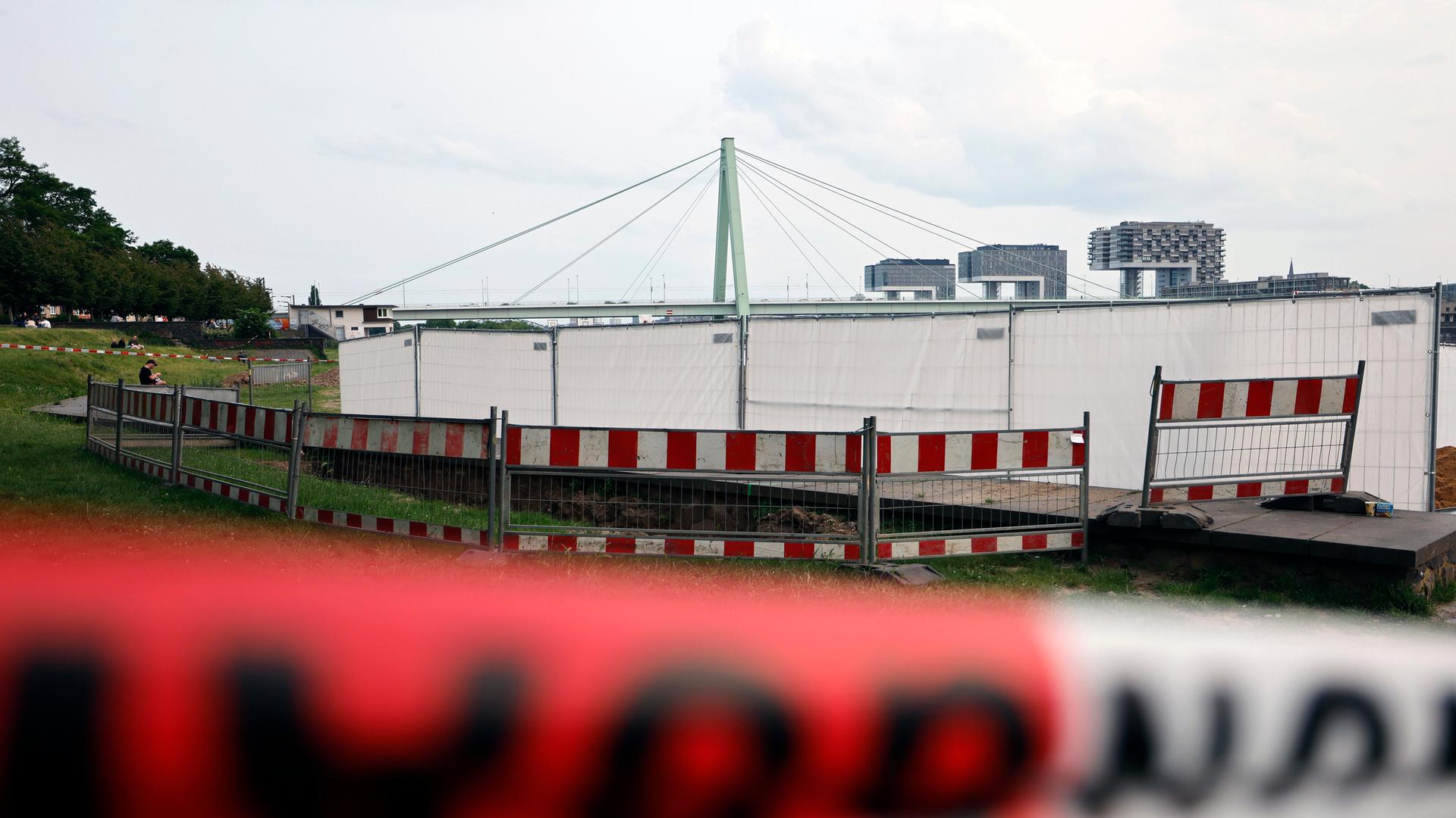 Für die Entschärfung der drei Weltkriegsbomben wurde der Fundort mit Sichtschutzwänden und Zäunen abgesperrt. Im Hintergrund sieht man die Pfeiler einer Rheinbrücke und die drei Kranhäuser. Für die Entschärfung der drei Weltkriegsbomben wurde der Fundort mit Sichtschutzwänden und Zäunen abgesperrt. Im Hintergrund sieht man die Pfeiler einer Rheinbrücke und die drei Kranhäuser.