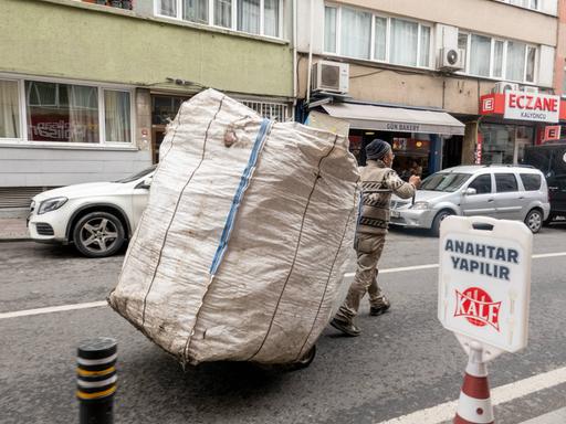 Ein Mann fährt mit einem Karren mit einem großen weißen Sack durch die Straße in Istanbul und sammelt Wertstoffe von Haushalten und Unternehmen,Türkei 2023.