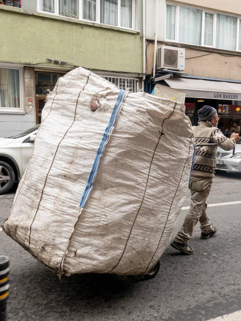 Ein Mann fährt mit einem Karren mit einem großen weißen Sack durch die Straße in Istanbul und sammelt Wertstoffe von Haushalten und Unternehmen,Türkei 2023.