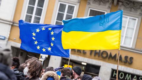 Auf einer Demonstration sind die europäische und die ukrainische Flagge zu sehen.