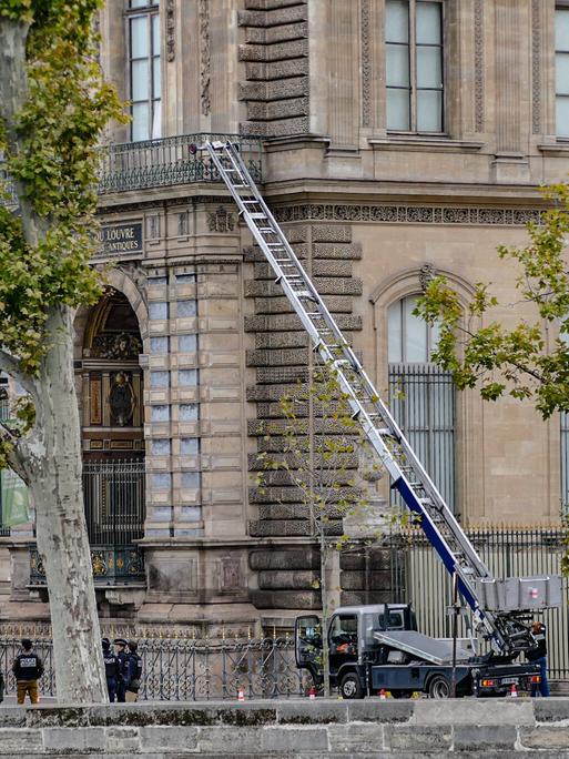 Eine auf einen Lkw montierte Leiter führt auf einen Balkon des Louvre