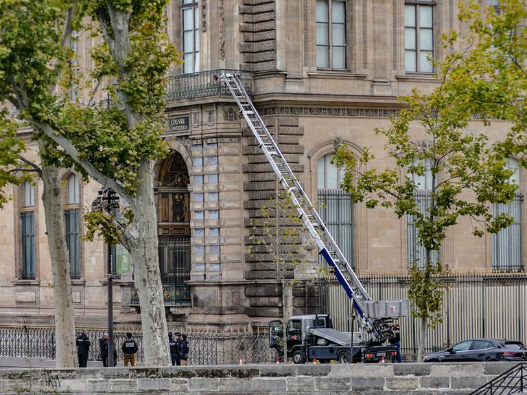 Eine auf einen Lkw montierte Leiter führt auf einen Balkon des Louvre