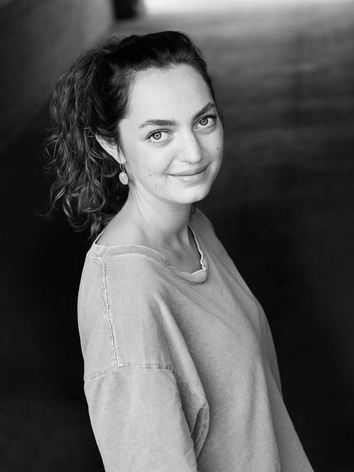 Schwarz-Weiß-Porträt der Schriftstellerin Dana Vowinckel. Sie schaut ein Stück weit von unten und der Seite in die Kamera.