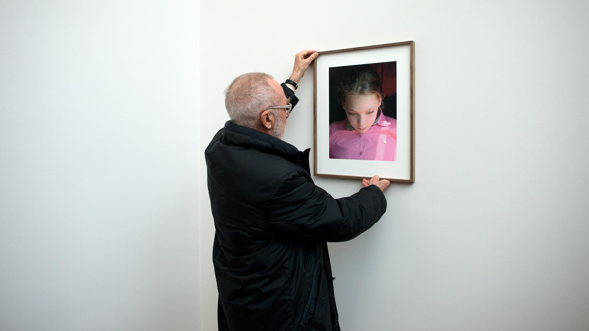 Der Maler Gerhard Richter hängt ein Bild seiner Tochter Ella auf.