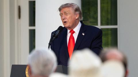 Donald Trump spricht an einem Rednerpult zu einer Gruppe von Menschen. Im Vordergrund steht eine Person mit einem großen Cowboyhut. Donald Trump spricht an einem Rednerpult zu einer Gruppe von Menschen. Im Vordergrund steht eine Person mit einem großen Cowboyhut.