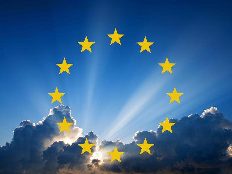 Wolken am Himmel, durch die Sonne scheint. Darauf eine Grafik der 12 gelben Sterne der europäischen Flagge. 