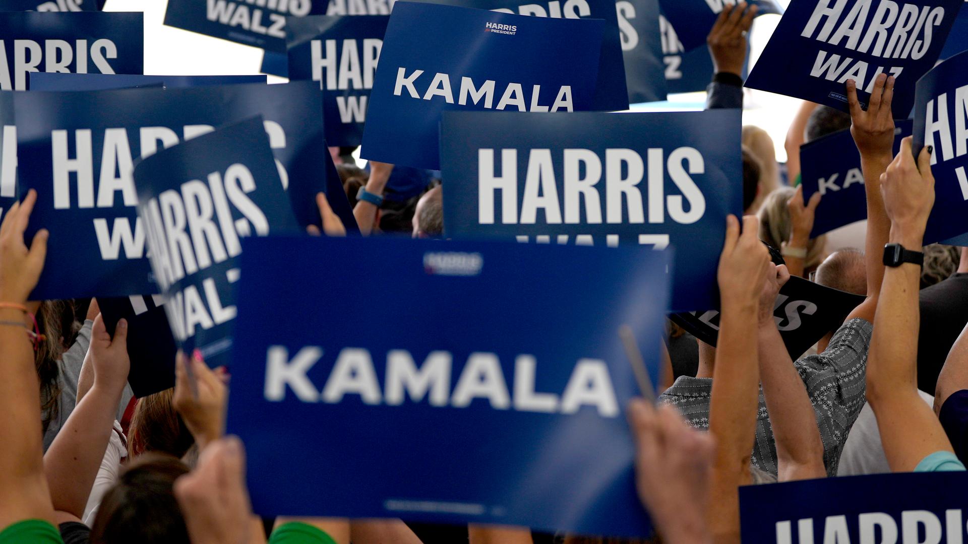 Unterstützer der Politikerin Kamala Harris halten Schilder in die Höhe. Auf diesen steht "Harris" oder "Kamal". 