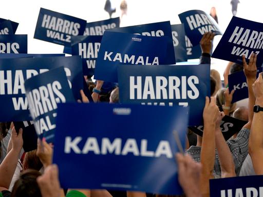 Unterstützer der Politikerin Kamala Harris halten Schilder in die Höhe. Auf diesen steht "Harris" oder "Kamal". 