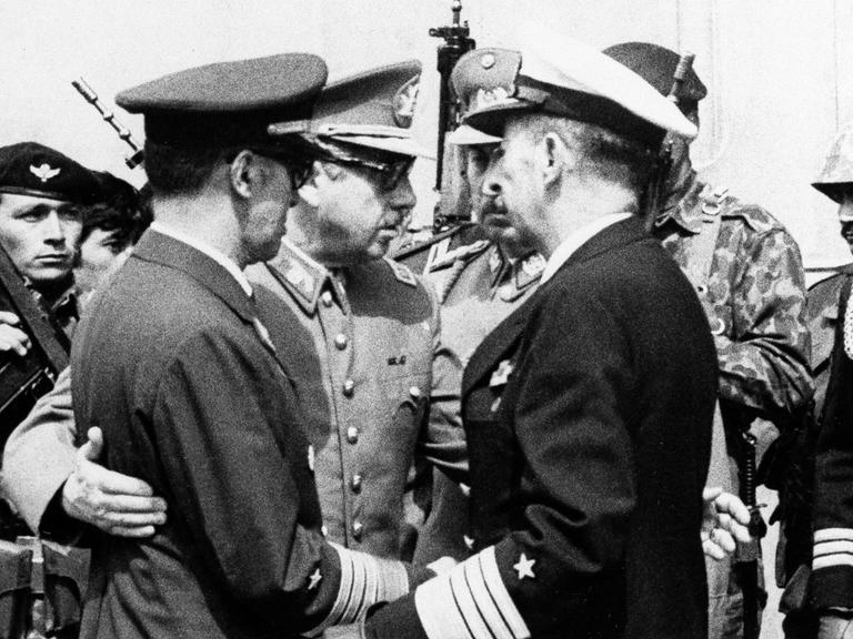 Historisches Schwarzweißfoto zeigt Militärs. Dabei Junta-Chef und späteren Diktator Augusto Pinochet einen Offizier umarmend.