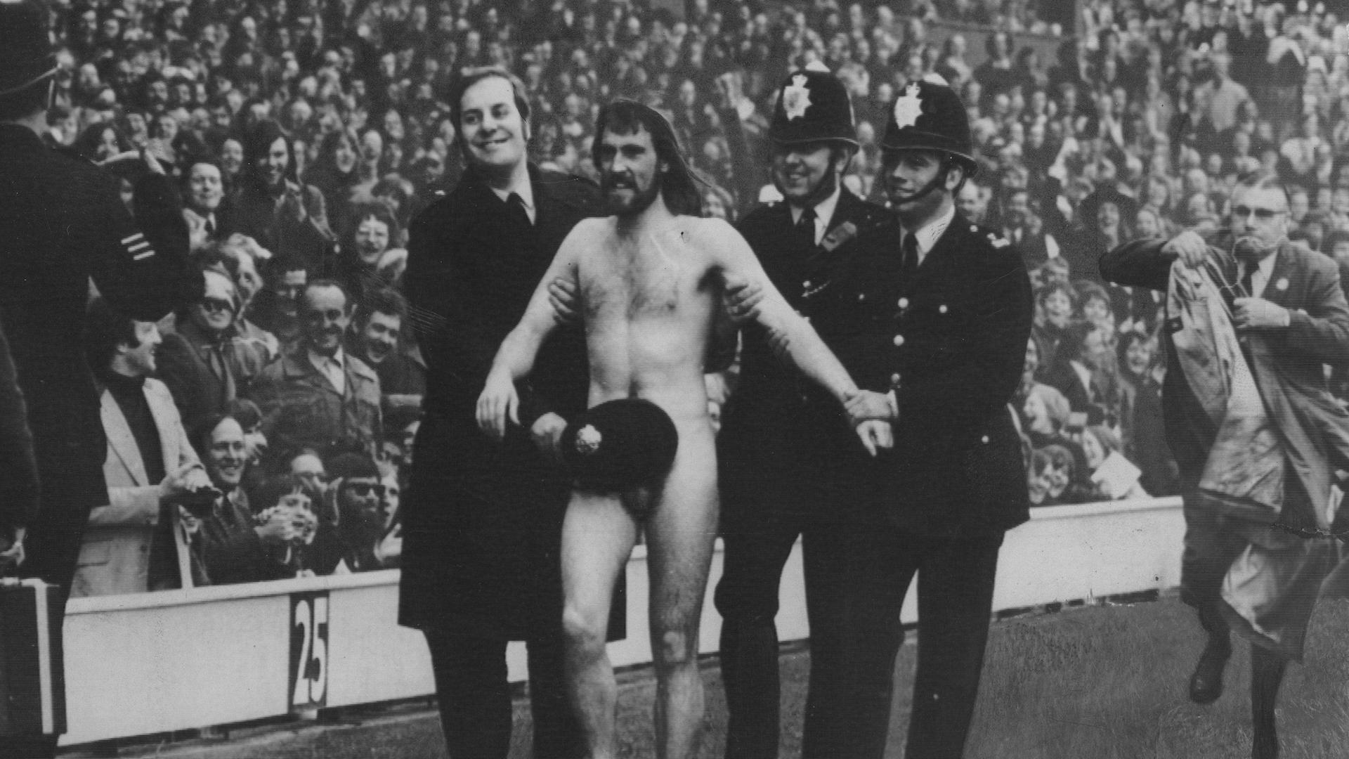Der Flitzer Michael O´Brien, eskortiert von Polizisten, wird am 1. April 1974 in London im Stadion Twickenham vom Platz geführt.
