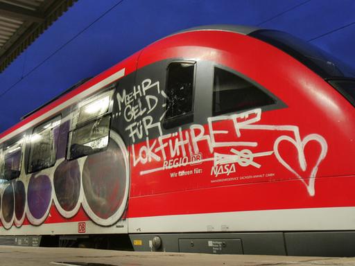 Eine Regionalbahn mit dem Graffiti-Schriftzug "Mehr Geld für Lokführer" steht am Donnerstagmorgen (18.10.2007) auf einem Gleis im Hauptbahnhof in Magdeburg. Der neuerliche Streik der Gewerkschaft der Lokführer (GDL) hat vor allem in Ostdeutschland zu erheblichen Störungen im Nahverkehr geführt. Der bundesweite Ausstand begann um 02.00 Uhr. Foto: Jens Wolf dpa/lah +++(c) dpa - Report+++