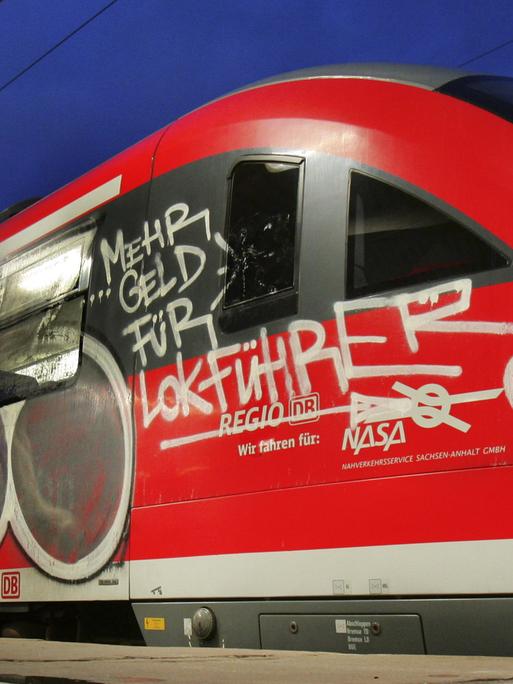 Eine Regionalbahn mit dem Graffiti-Schriftzug "Mehr Geld für Lokführer" steht am Donnerstagmorgen (18.10.2007) auf einem Gleis im Hauptbahnhof in Magdeburg. Der neuerliche Streik der Gewerkschaft der Lokführer (GDL) hat vor allem in Ostdeutschland zu erheblichen Störungen im Nahverkehr geführt. Der bundesweite Ausstand begann um 02.00 Uhr. Foto: Jens Wolf dpa/lah +++(c) dpa - Report+++