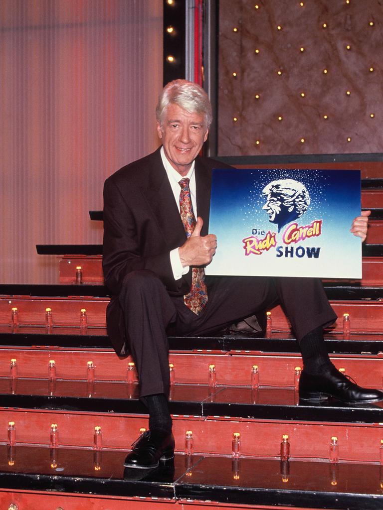 Showmaster und Entertainer Rudi Carrell posiert mit dem Logo der Rudi Carrell Show auf der Showtreppe im Jahre 1992