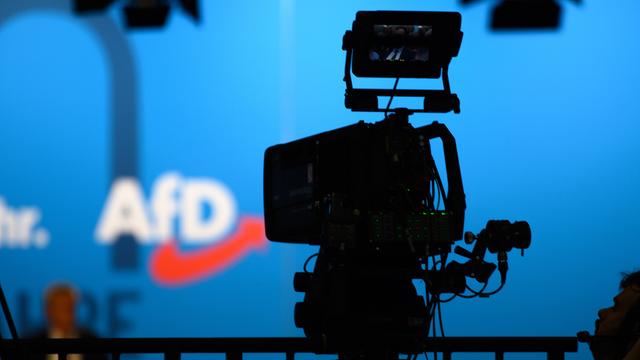 Eine Fernseh-Kamera zeigt auf ein Logo der Partei AfD.