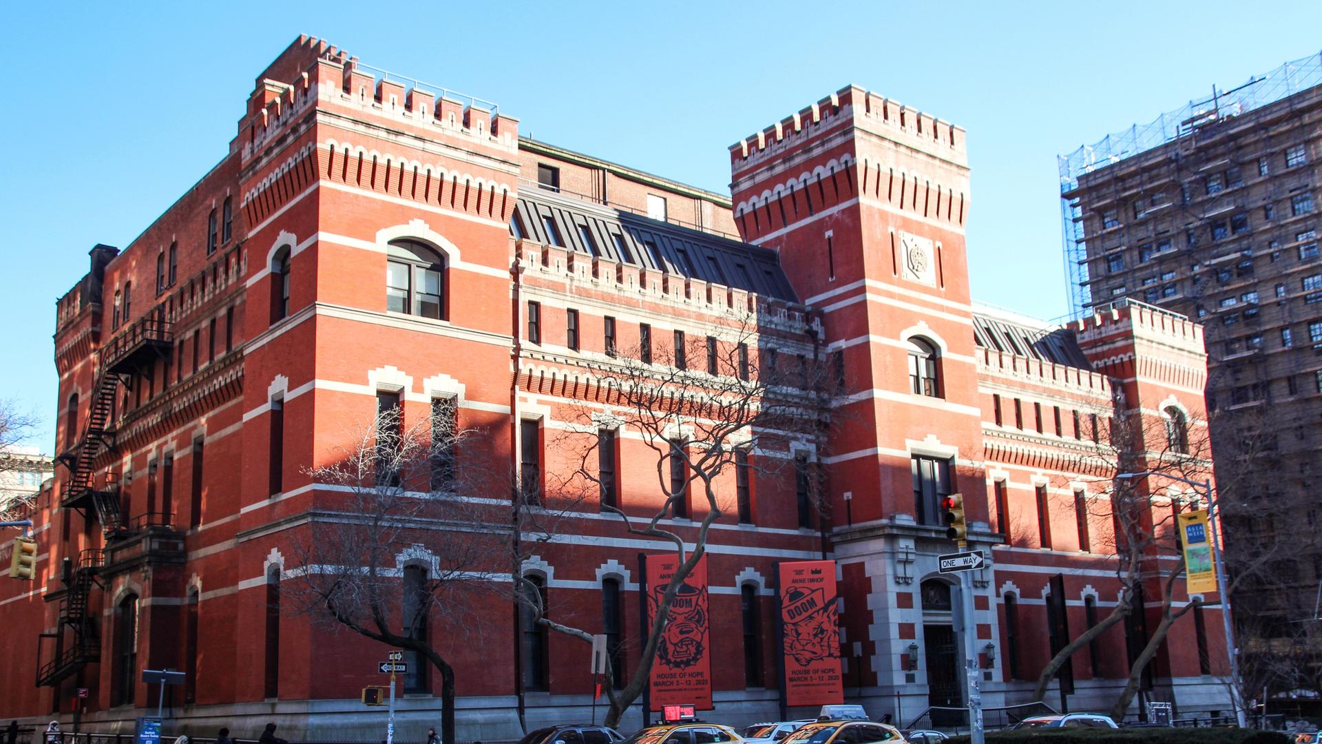 Das wie eine Ritterburg mit Türmen gestaltete Park Avenue Armory Center, davor stehen Autos an einer Kreuzung.