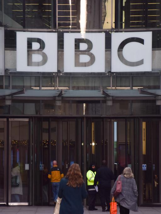 Vor dem Eingang des Broadcasting House, dem Hauptsitz der BBC in London, sind Menschen zu sehen.
Vor dem Eingang des Broadcasting House, dem Hauptsitz der BBC in London, sind Menschen zu sehen.