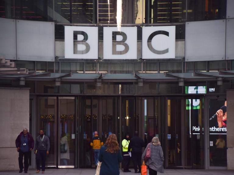 Vor dem Eingang des Broadcasting House, dem Hauptsitz der BBC in London, sind Menschen zu sehen.
Vor dem Eingang des Broadcasting House, dem Hauptsitz der BBC in London, sind Menschen zu sehen.