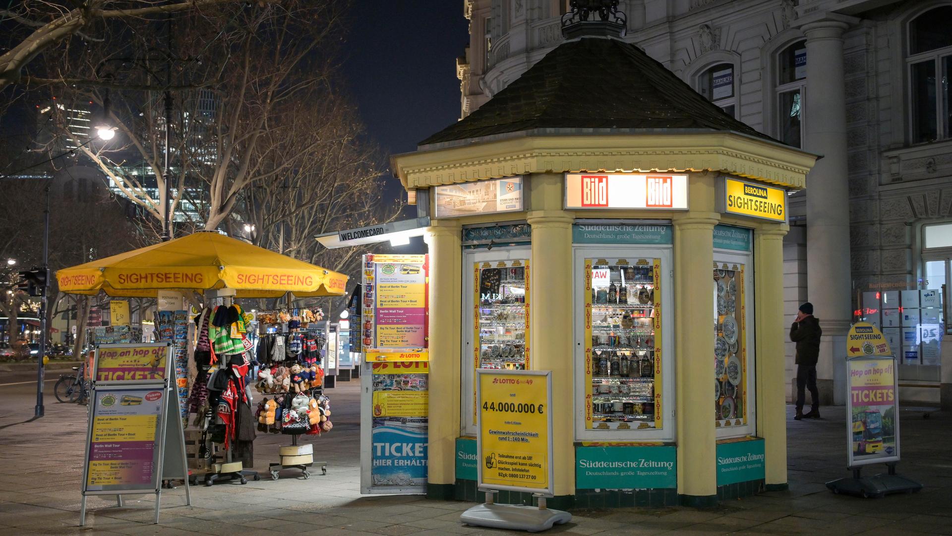 Der Kiosk in Form eines Pavillons steht beleuchtet auf dem nächtlichen Kurfürstendamm.