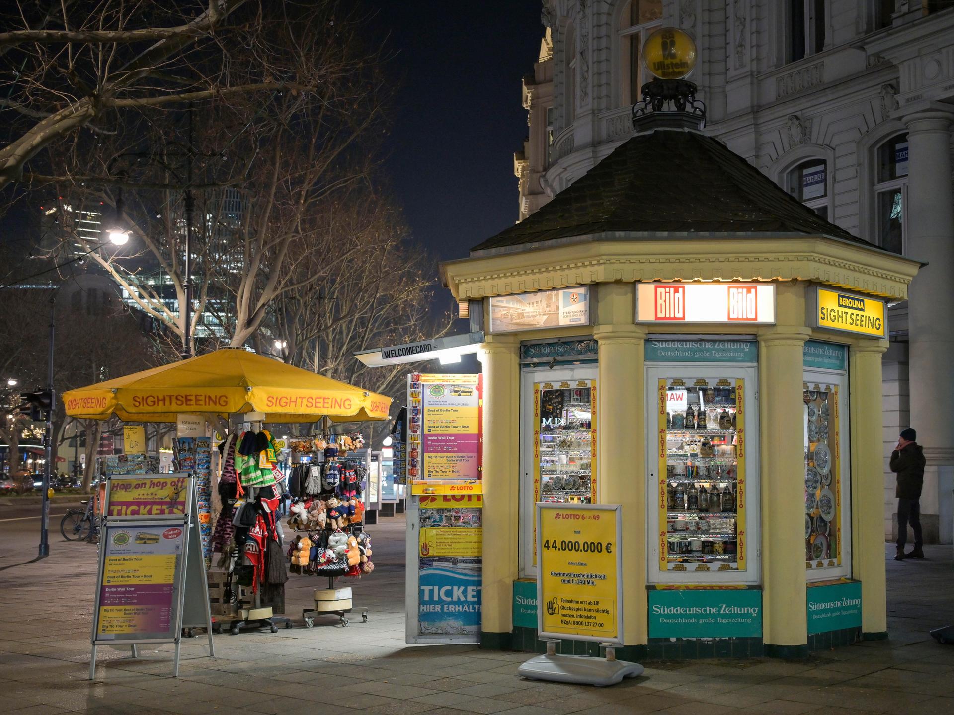 Der Kiosk in Form eines Pavillons steht beleuchtet auf dem nächtlichen Kurfürstendamm.