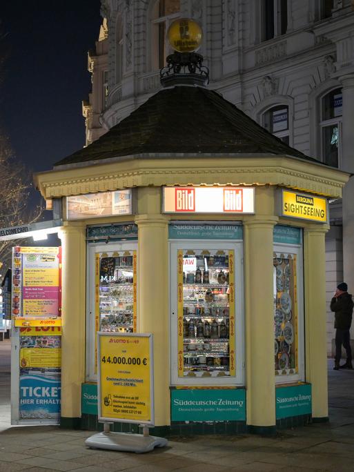 Der Kiosk in Form eines Pavillons steht beleuchtet auf dem nächtlichen Kurfürstendamm. Der Kiosk in Form eines Pavillons steht beleuchtet auf dem nächtlichen Kurfürstendamm.