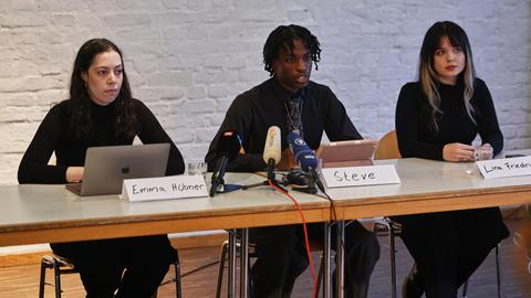 Emma Hübner, Steve und Lina Friedrich (v.li.), Organisatoren der Initiative "Gen Z regelt", sprechen auf einer Pressekonferenz vor den bundesweiten Demonstrationen am Samstag (31.10.). Sie sitzen an einem Tisch vor Mikrofonen.