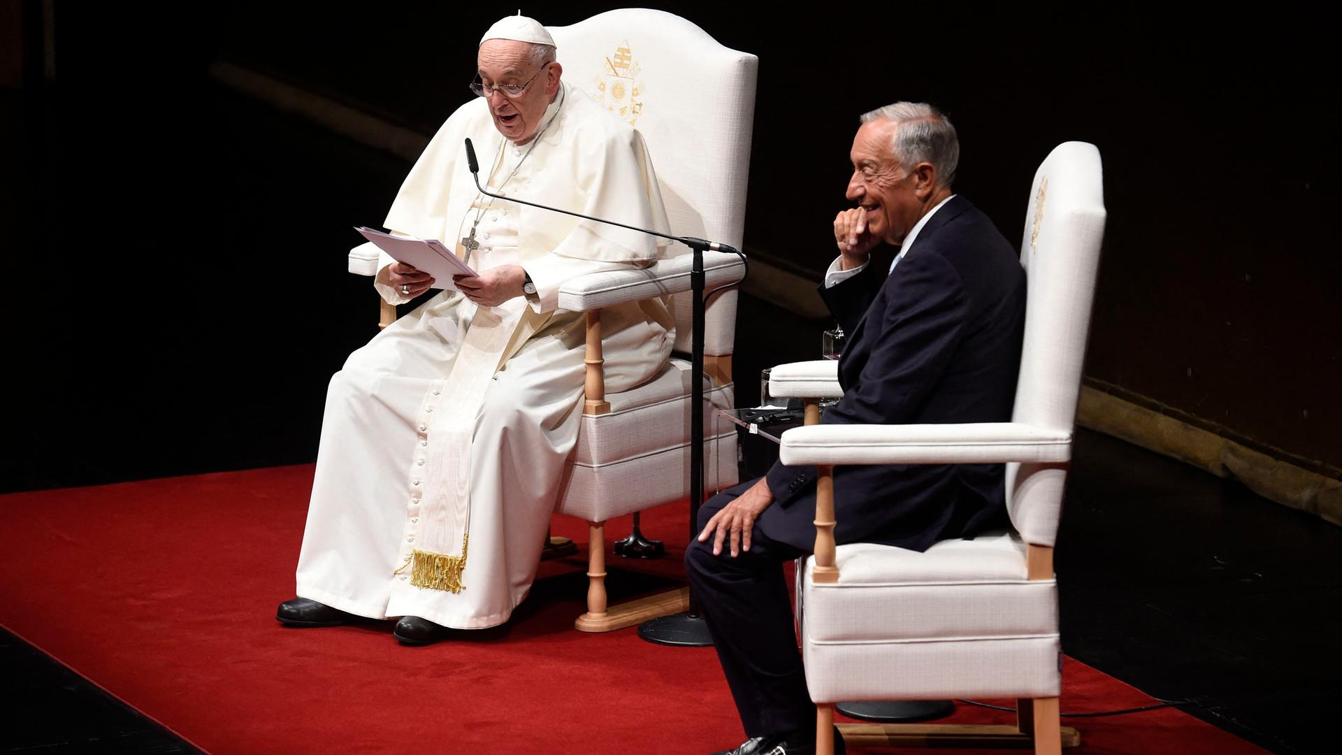 Papst Franziskus hält eine Rede. Neben ihm sitzt der portugiesische PRäsident de Sousa mit auf der Bühne.