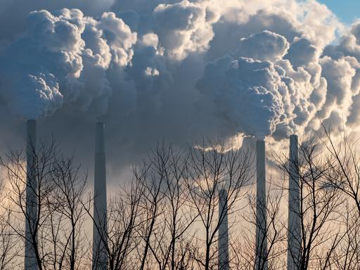 Rauchwolken steigen aus riesigen Industrieschornsteinen auf.