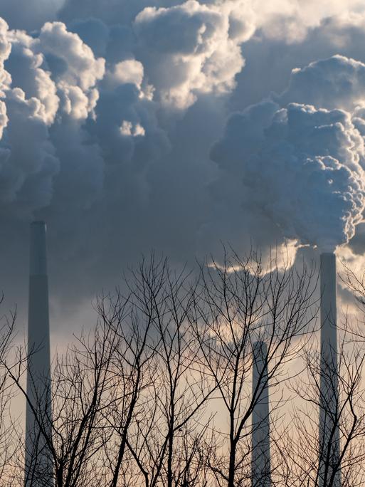 Rauchwolken steigen aus riesigen Industrieschornsteinen auf.