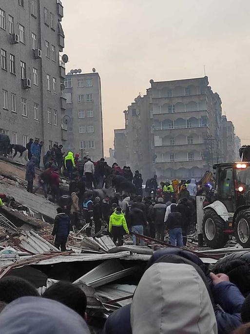 Das Foto zeigt Räumungsarbeiten und die Suche nach Verschütteten in den Trümmern nach einem Erdbeben in der Türkei. 