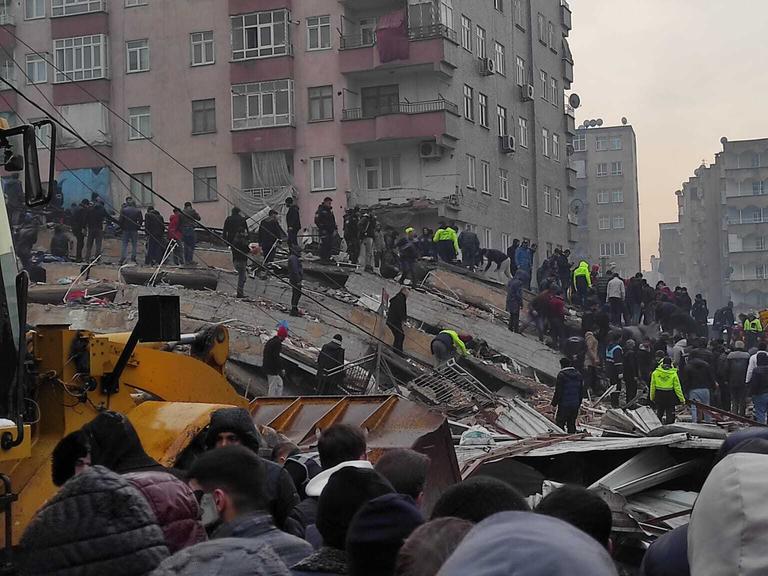 Das Foto zeigt Räumungsarbeiten und die Suche nach Verschütteten in den Trümmern nach einem Erdbeben in der Türkei. 