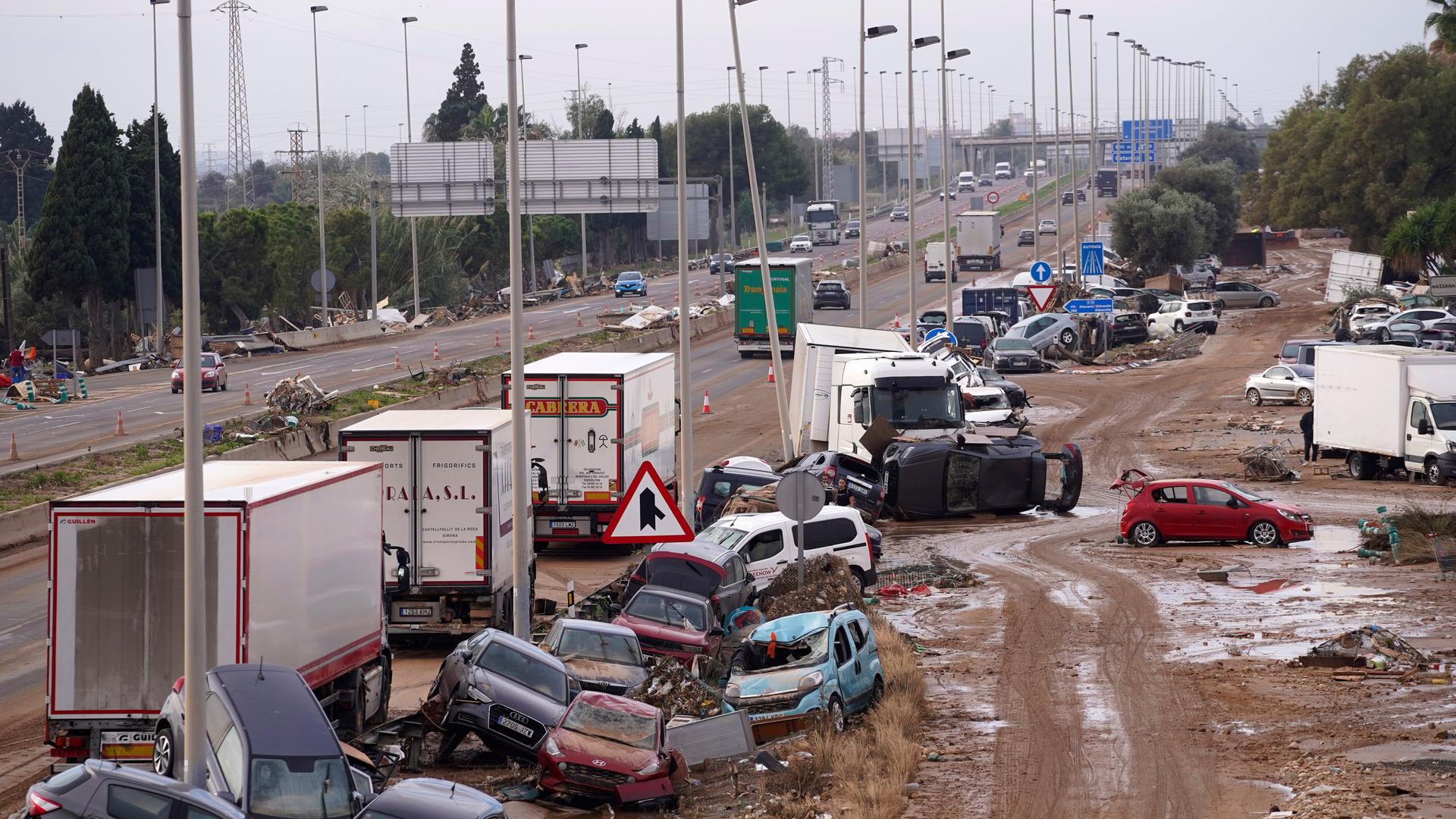 Spanien, Valencia: Autos liegen nach den Überschwemmungen auf der Seite einer Hauptstraße. Fo Spanien, Valencia: Autos liegen nach den Überschwemmungen auf der Seite einer Hauptstraße. Fo